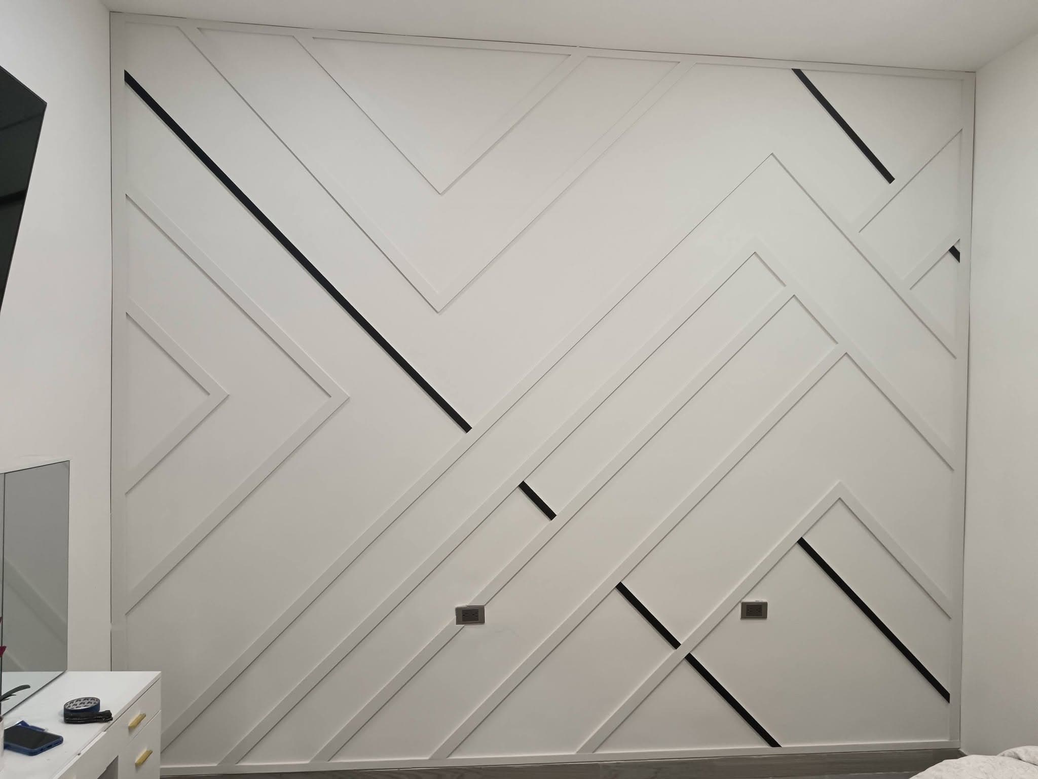 Moldura decorativa geométrica con acabado blanco e inserciones negras en recámara, proyecto de Contraste en Hermosillo, Sonora
