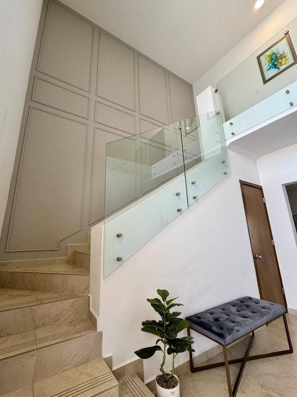 Escalera con moldura de panel taupe, barandal de vidrio y decoración de interiores, proyecto de Contraste en Hermosillo Sonora