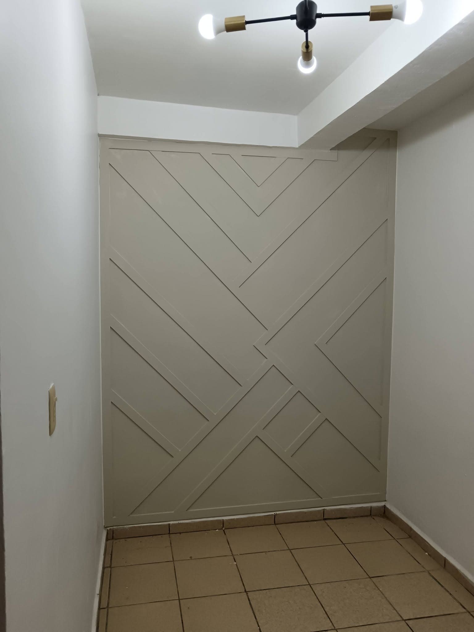 Acabado de lujo con moldura geométrica en muro color taupe, proyecto de Contraste en Hermosillo Sonora